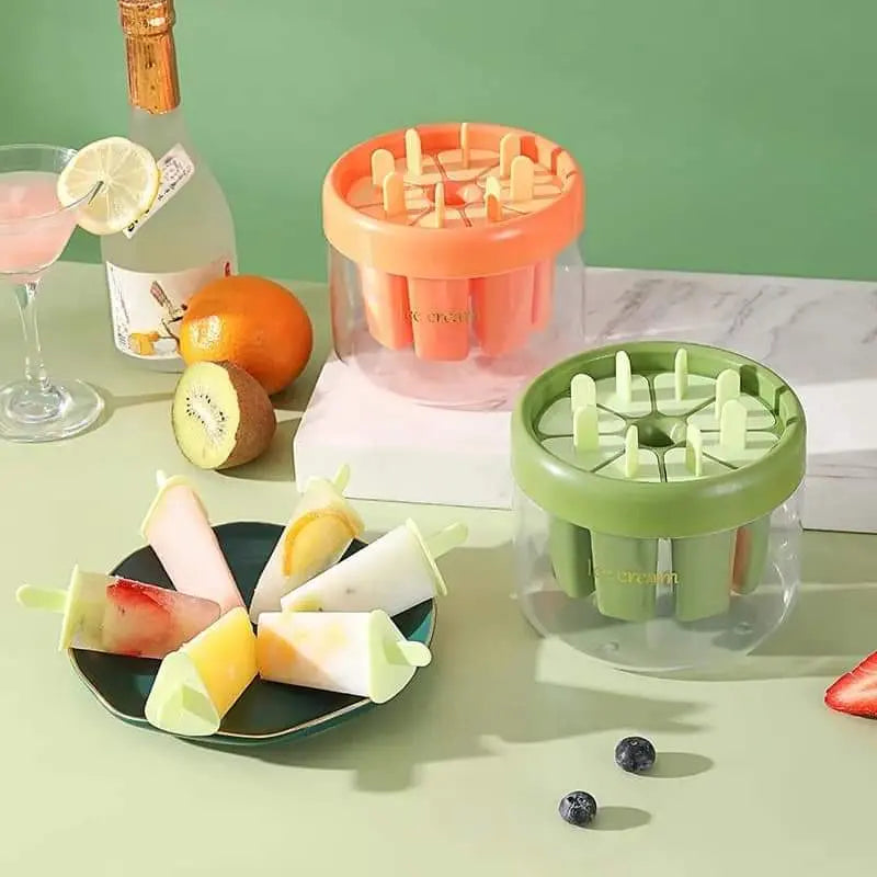 Popsicle molds with colorful popsicles on a table with fruits and drinks.